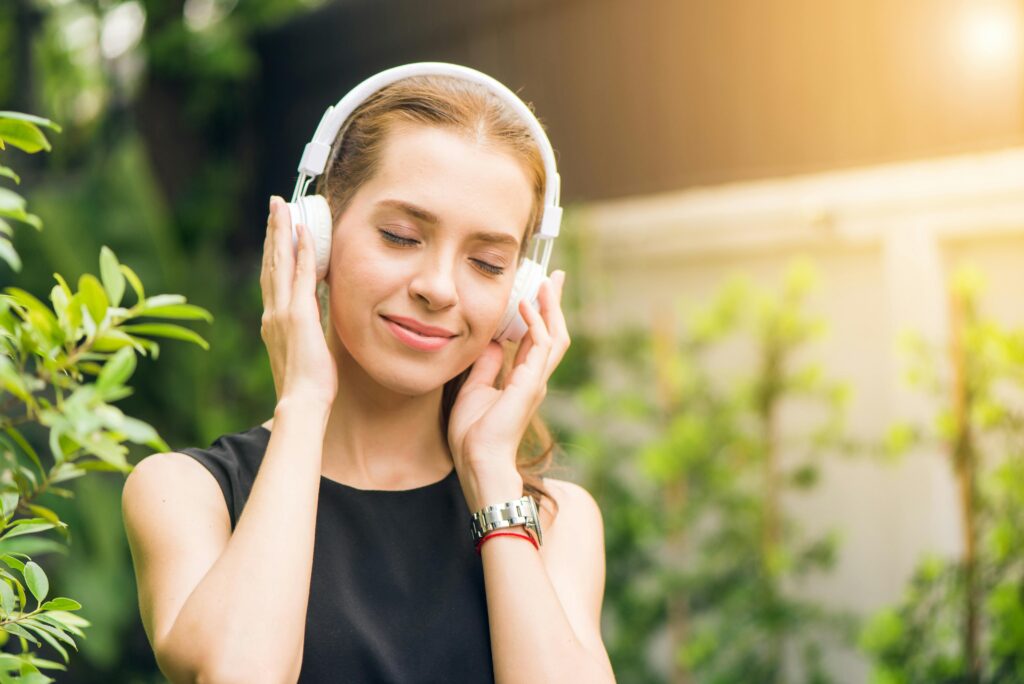 a happy person listening to music to strengthen her vital energy